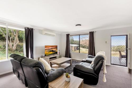 a living room with two couches and a tv at Deer Valley Farm Stay Illawarra sleeps up to 9 in Kembla Grange