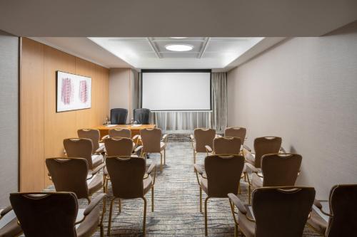 a room with a bunch of chairs and a projection screen at InterContinental Athenee Palace Bucharest by IHG in Bucharest