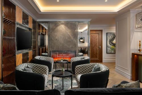 a lobby with chairs and a table and a television at InterContinental Athenee Palace Bucharest by IHG in Bucharest