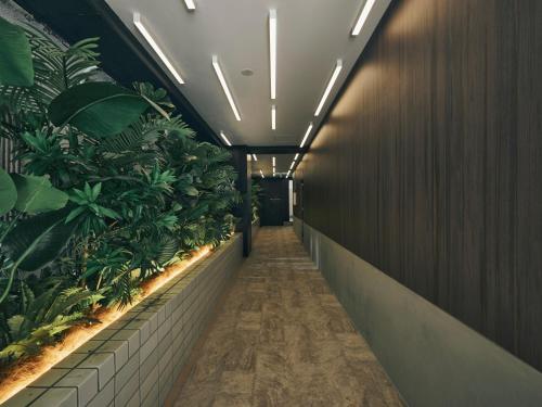 a hallway with plants on the walls of a building at illi Rom Hamamatsucho in Tokyo
