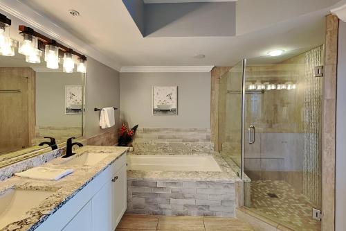 un baño con dos lavabos y una ducha en Silver Shells, en Destin