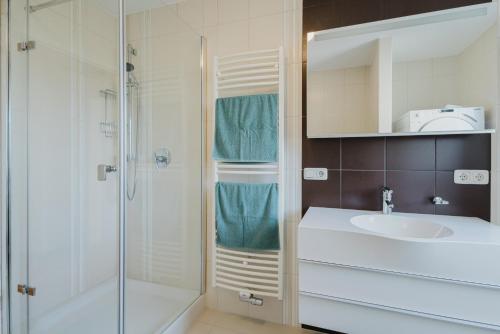 a white bathroom with a sink and a shower at FerienWohnenSieglinde in Weiden
