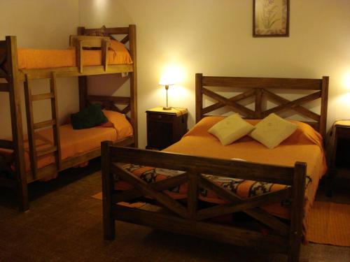 1 dormitorio con 2 literas y escalera en Las Acacias - Posada de Campo en Villa General Belgrano