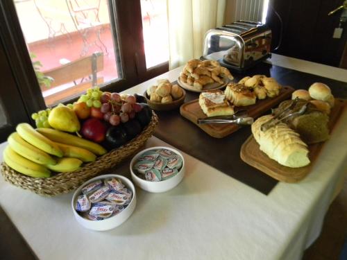 a table topped with different types of bread and fruit at Las Acacias - Posada de Campo in Villa General Belgrano