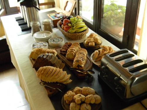 une table recouverte de beaucoup de différents types de nourriture dans l'établissement Las Acacias - Posada de Campo, à Villa General Belgrano