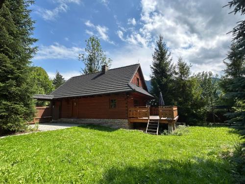 a log cabin in the middle of a yard at Chata KORSO v súkromí so záhradou 1200m2 in Terchová