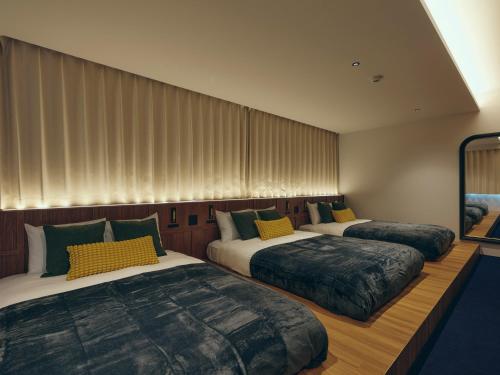 three beds are lined up in a room at illi Surp Shiba-Park in Tokyo