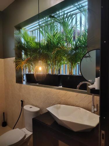 a bathroom with a sink and a mirror with plants at Arthana Diamond in Nusa Dua