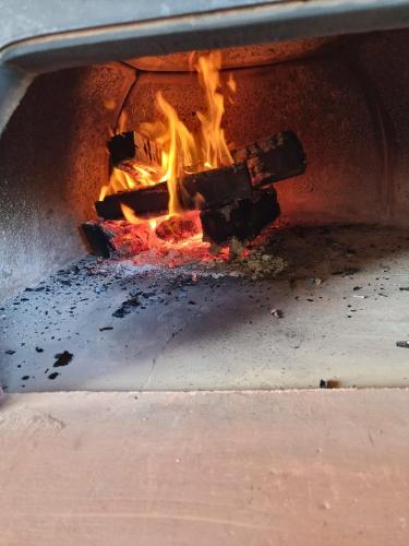a fire is coming out of an oven at CASA DEL CANTA in Borgomale