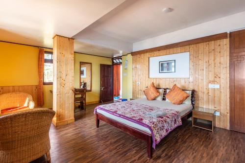 a bedroom with a bed and a chair in it at Little Singamari Home Stay in Darjeeling