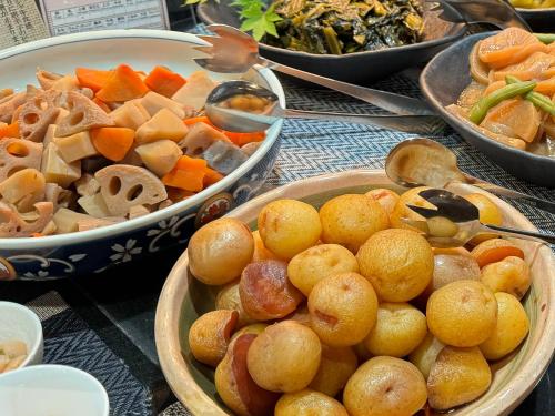 a table with bowls of food and bowls of vegetables at Hotel Kusakabe Armeria in Gero