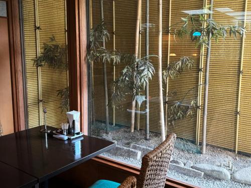 a table and chairs in front of a window at Hotel Kusakabe Armeria in Gero
