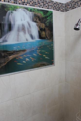 a painting of a waterfall on the wall of a bathroom at NARU Extremo in Utica