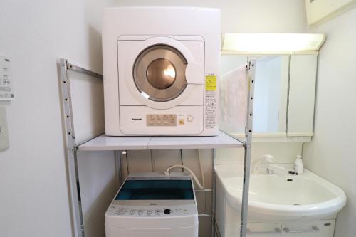 a washer and dryer on a shelf in a bathroom at Ideal Yuuhigaoka イデアール夕陽丘 in Osaka