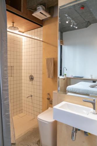 a bathroom with a sink and a shower and a toilet at HomeBase Apartment Hotel in Manila
