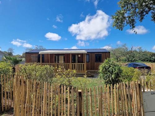 une maison en bois derrière une clôture en bois dans l'établissement Mobilhome tout confort, à La Teste-de-Buch