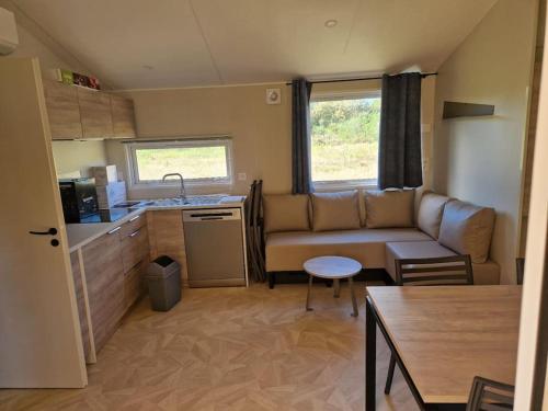un petit salon avec un canapé et une cuisine dans l'établissement Mobilhome tout confort, à La Teste-de-Buch