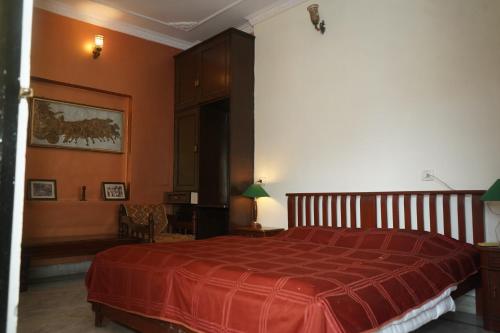 a bedroom with a bed with a red blanket at Haveli Katkoun in Būndi