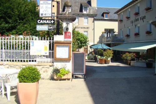 a street with a sign in front of a building at Hotel Le Lion d'Or in Saint-Geniez-dʼOlt
