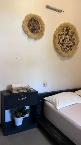 a bedroom with two beds and a nightstand with a bed sidx sidx at Mambo & Jambo Homestay in Mwanza
