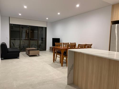a kitchen and dining room with a table and chairs at Schofields Brand New 2 Br Apt Parking Privacy in Schofields
