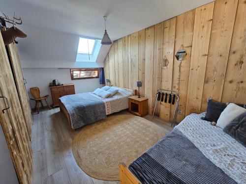 a bedroom with two beds and wooden walls at Chambres d'hôtes Olachat proche Annecy in Faverges