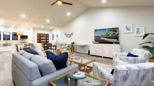 a living room with couches and a table at ❤PiH❤Aloha Paradise Large Private Pool Waterfall Spa PLUS 2024 Resort Pool Passes in Waikoloa