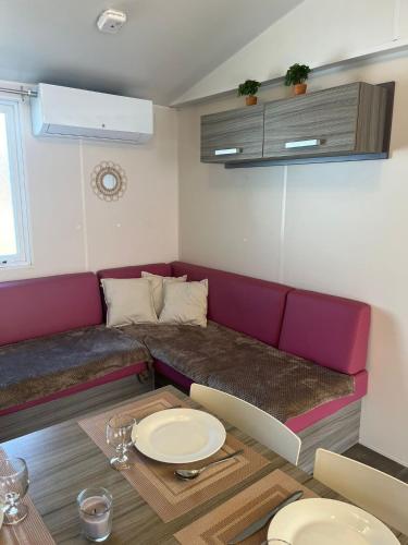 un salon avec un canapé et une table dans l'établissement Le Refuge du Bassin - Mobil-home 6 personnes 40m2, à Claouey