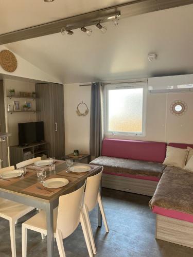 - un salon avec une table à manger et un lit dans l'établissement Le Refuge du Bassin - Mobil-home 6 personnes 40m2, à Claouey