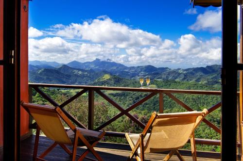two chairs on a porch with a view of mountains at Pousada Portal Dos Ventos in Visconde De Maua