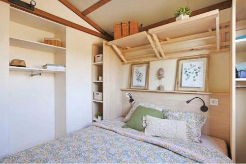 Habitación pequeña con cama y estanterías en Mobilhome 6 couchages camping 4 étoiles, en La Hume