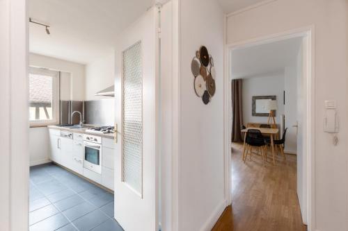 Il comprend une cuisine équipée d'appareils blancs et une salle à manger avec une table. dans l'établissement le schwendi, à Colmar