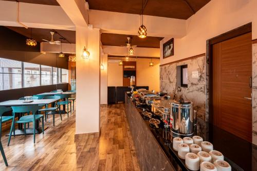 a restaurant with tables and chairs and a counter at Hotel Stay Bella Kozhikode in Kozhikode