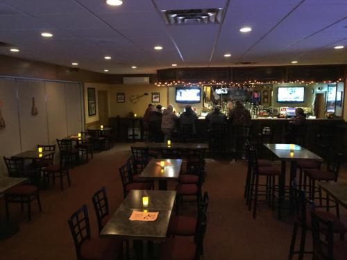 a restaurant with tables and chairs and a bar at Shallow Bay Motel & Cabins Conference Centre in Cow Head