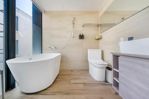 a bathroom with a white tub and a toilet at Ningxia Ocean in Yilan City