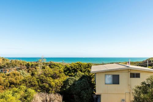 a house with the ocean in the background at Ninettas Views - Great coastal location in Guilderton