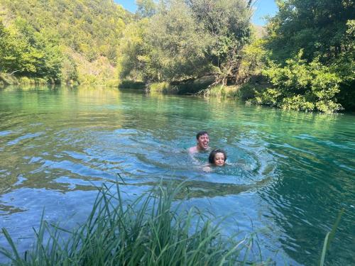 a man and a woman swimming in a river at Gourgiana Apartments in Andritsaina