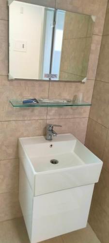 a bathroom with a white sink and a mirror at Zhuge Hospitality Homestay in Tainan