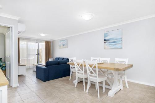 a living room with a table and a blue couch at Escape to 28 at Cape View in Broadwater