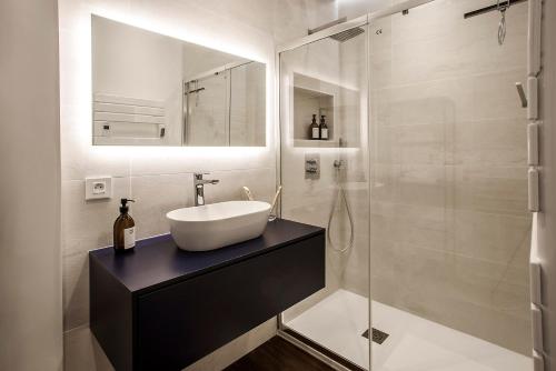a bathroom with a sink and a glass shower at Appartement entier avec place de parking in Angoulême