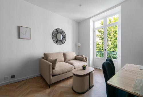 a living room with a couch and a table at Résidence Serbie - Appartements design et climatisés en centre ville in Vichy