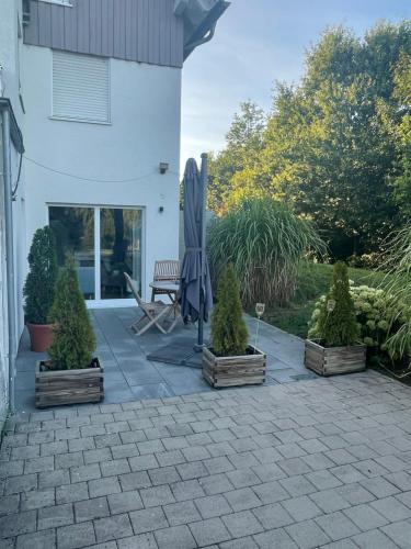 a patio with an umbrella and trees and a bench at Im Feldle in Kirchheim am Ries