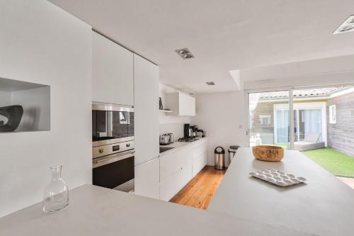 une cuisine avec des placards blancs et un comptoir blanc dans l'établissement Superbe loft avec patio à Bordeaux, à Bordeaux
