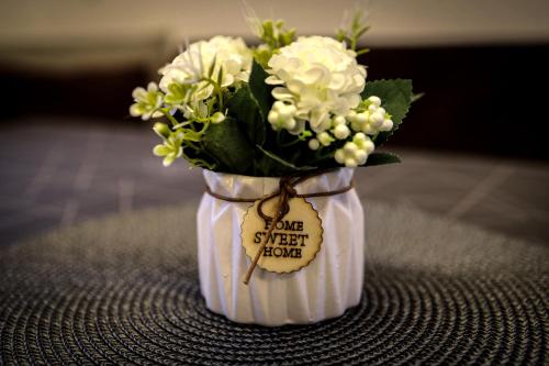 a small vase with flowers in it with a note at Apartments Gabl in Schönwies