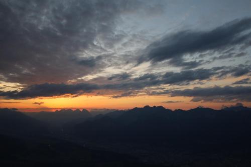 a sunset over a mountain range with clouds in the sky at Apartments Gabl in Schönwies