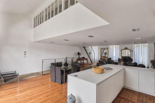 Il dispose d'une cuisine et d'un salon avec un grand plafond blanc. dans l'établissement Superbe loft avec patio à Bordeaux, à Bordeaux