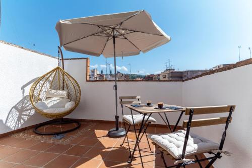 a patio with an umbrella and a table and chairs at Hotel Reina Mora in Granada