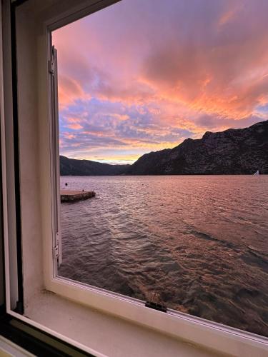 a window view of a sunset from a boat at Stone sea apartment in Risan