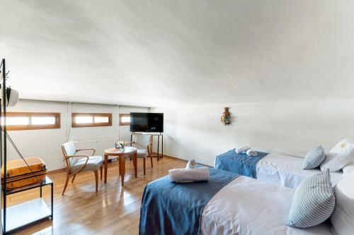 a hotel room with two beds and a television at Hotel Reina Mora in Granada
