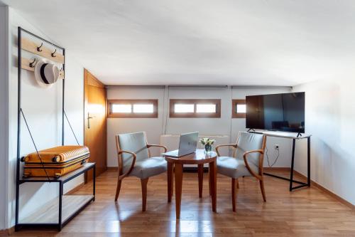 a room with a table and chairs and a kitchen at Hotel Reina Mora in Granada